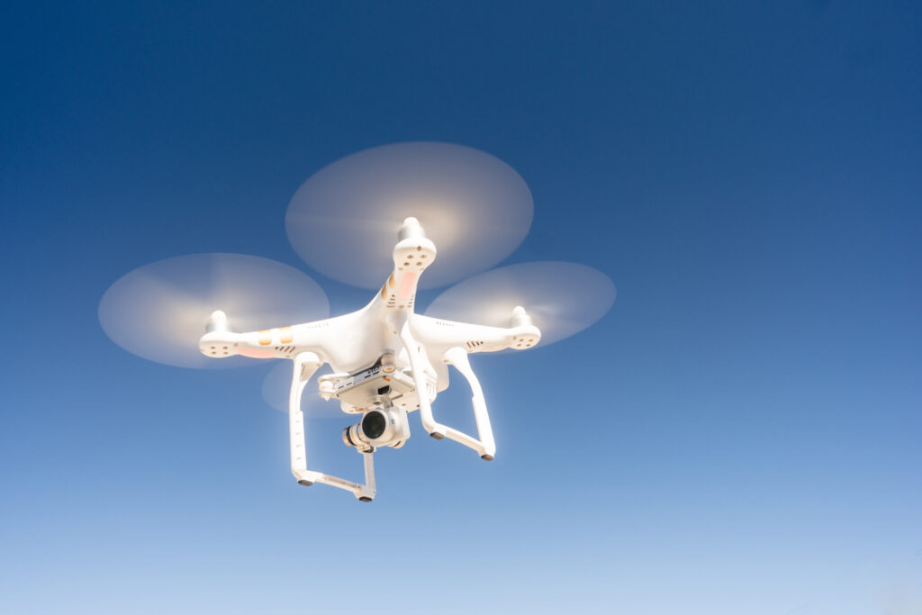 A Quadcopter hovering against a dark blue sky in a long panoramic composition